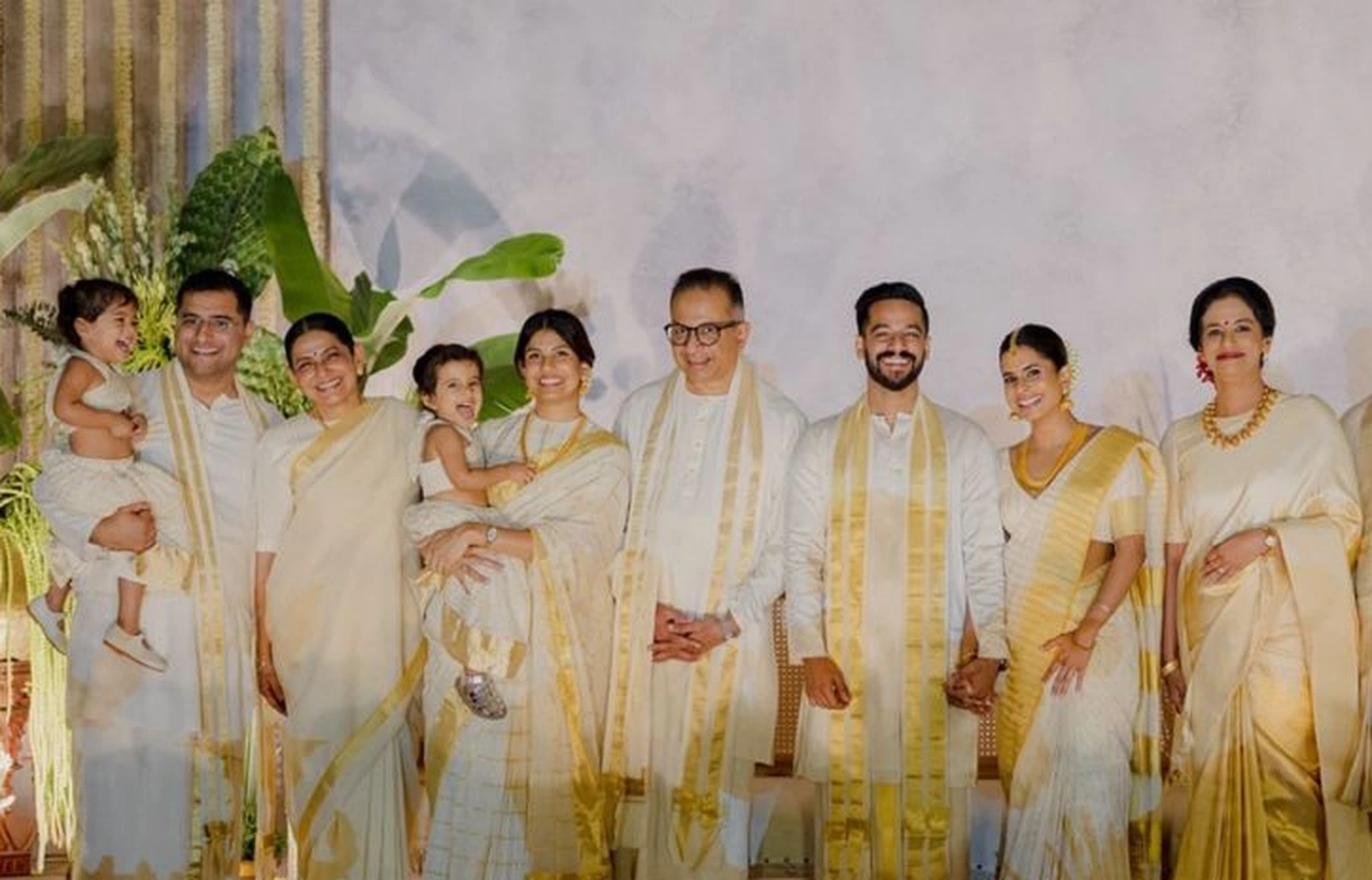 A family wearing ivory and gold Kerala kasavu sarees and mundus